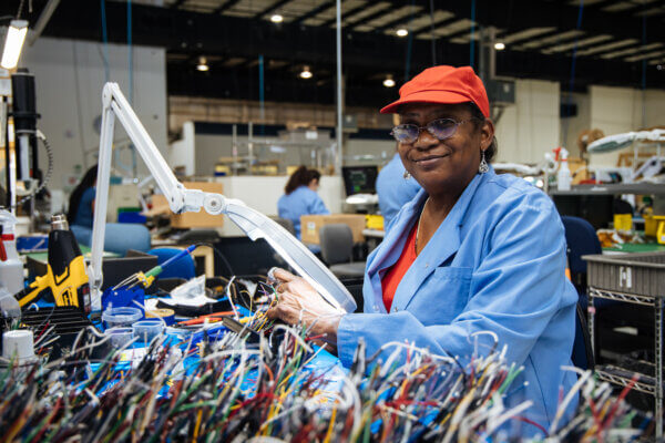 black woman in wire cable factory smiling